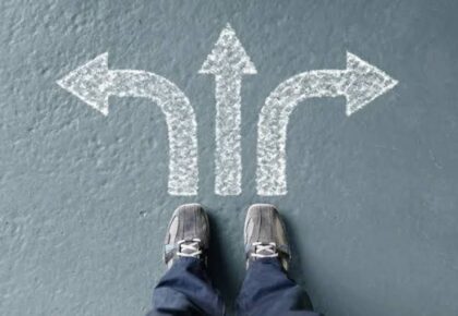 bir adam oklarla asfalta oklarla çizilmiş okların üstünde durmakta